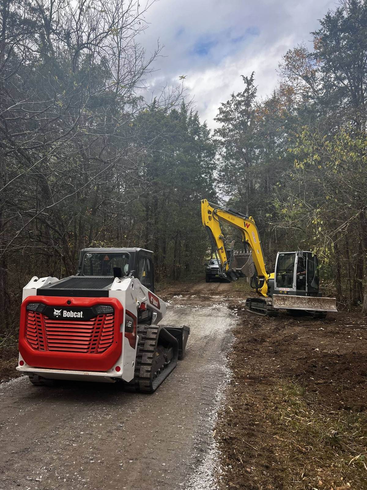 Michael Way Acres excavator and skid steer clearing a wooded homesite