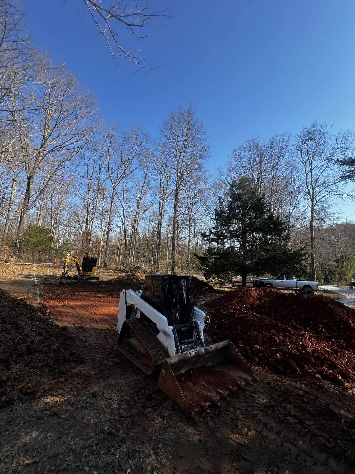Skid steer spreading erosion-control fabric on a graded site